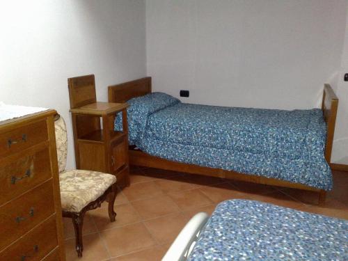 1 dormitorio con 2 camas, silla y cómoda en Villa Stefy en Dervio