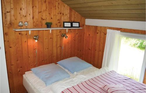 Jerupにある3 Bedroom Nice Home In Jerupの木製の壁のドミトリールームのベッド1台分です。
