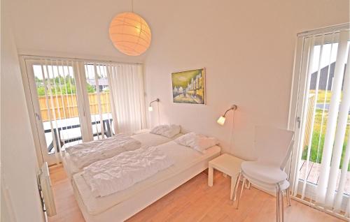 a white bedroom with a bed and a table and chairs at Awesome Home In Brovst With 3 Bedrooms, Sauna And Wifi in Brovst