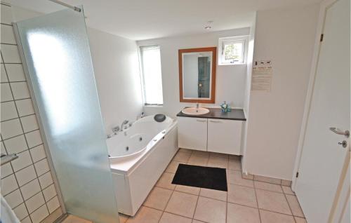 a bathroom with a tub and a sink at Awesome Home In Brovst With 3 Bedrooms, Sauna And Wifi in Brovst