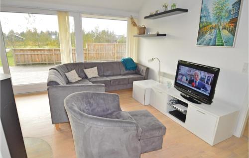 a living room with a couch and a tv at Holiday Home Kronvildtvej Brovst X in Brovst