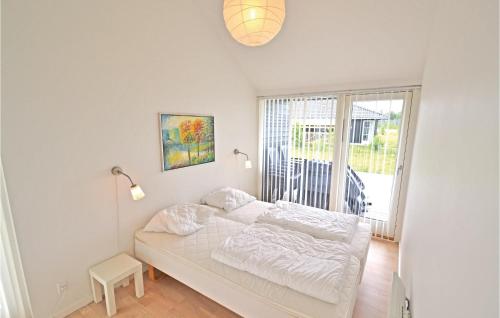 a white bed in a room with a window at Holiday Home Kronvildtvej Brovst X in Brovst