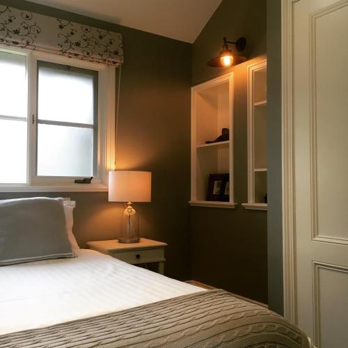 a bedroom with green walls and a bed and a window at Oak Tree Lodge in Rhyll