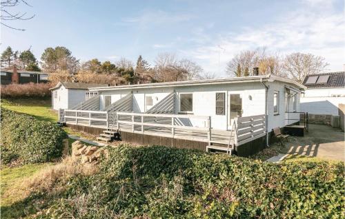 a white house with a porch on a hill at Two-Bedroom Apartment In Allinge in Allinge