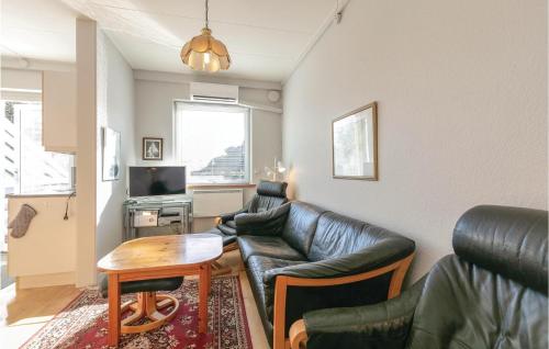 a living room with a leather couch and a table at Two-Bedroom Apartment In Allinge in Allinge