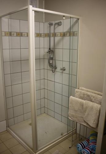 una ducha con puerta de cristal en un baño en Spring Homestead, en Howard Springs