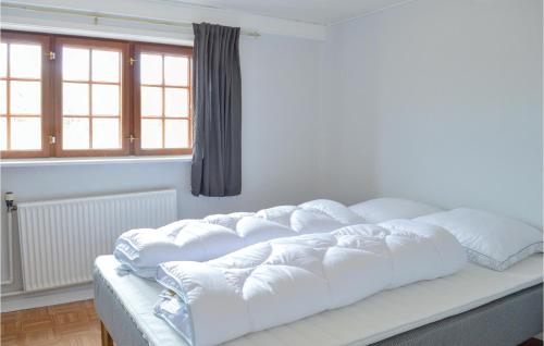 a large white bed in a room with a window at Beautiful Apartment In Rm With Wifi in Rømø Kirkeby
