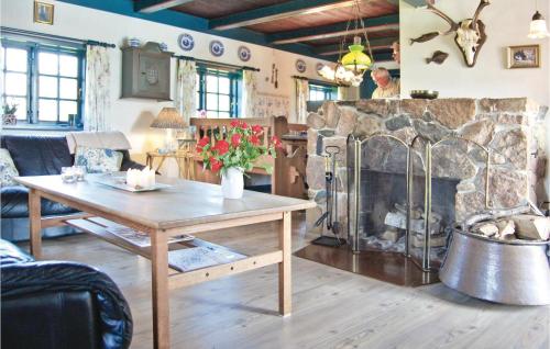 Una sala de estar con una mesa y una chimenea. en Holiday Home Bjerregårdsvej Ix, en Bjerregård