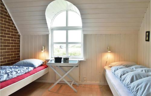 Nørre Lyngvigにあるskenのベッド2台、テーブル、窓が備わる客室です。