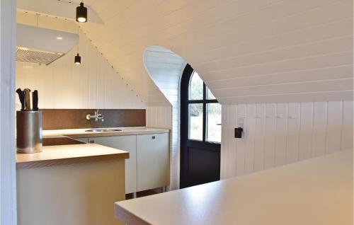 Nørre Lyngvigにあるskenの白いキャビネットと黒いドア付きのキッチン