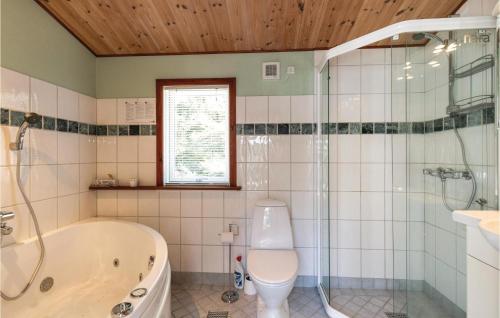 ein Badezimmer mit Badewanne, Toilette und Dusche in der Unterkunft Oâsan in Bedegård