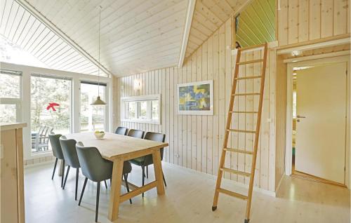 a dining room with a ladder and a table and chairs at Holiday Home Turistvej Nexø in Snogebæk