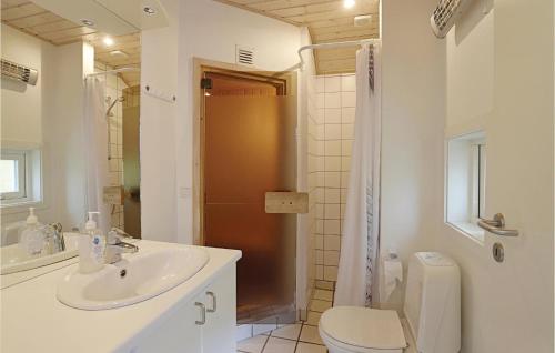a bathroom with a sink and a toilet and a shower at Cozy Home In Nex With Sauna in Snogebæk