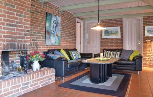 ein Wohnzimmer mit Sofas, einem Tisch und einer Ziegelwand in der Unterkunft Awesome Home In Ringkøbing With Kitchen in Klegod