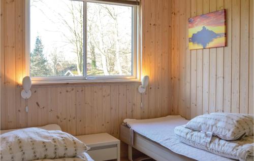 a room with two beds and a window at Holiday Home Solbakkevej Hornbæk Xii in Dronningmølle