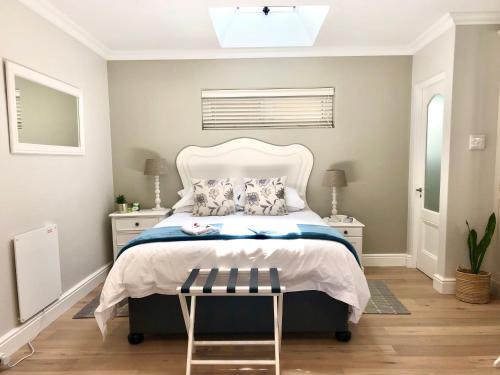 um quarto com uma cama com uma cabeceira branca em Garden Cottage - Leafy Constantia Guest House na Cidade do Cabo