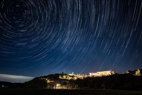 a star trail in the night sky over a city at GRAND CHARIOT Hokutoshichisei 135° in Awaji
