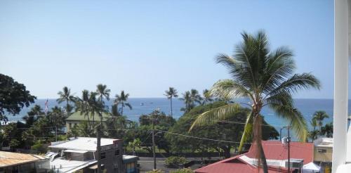 a view of the ocean from a building with a palm tree at Da Kona West 305 in Kailua-Kona