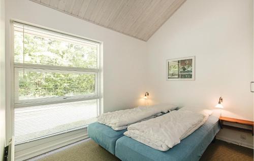 a bedroom with a bed and a large window at Rubinsen Skovhuse in Tofte