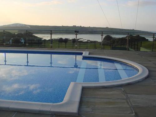 a large swimming pool next to a body of water at Apartamentos Rurales Los Solares in Mogro
