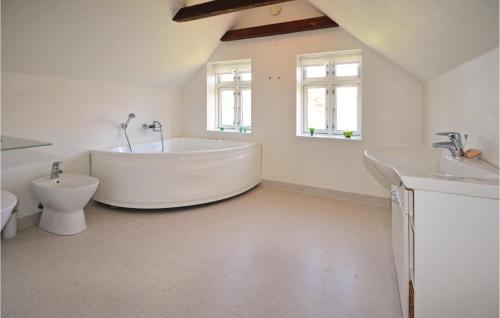 a large white bathroom with a tub and a toilet at Ven Havnehotel in Struer