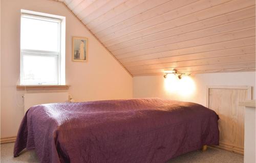 a bedroom with a purple bed in a attic at Nice Home In Ringkbing With 4 Bedrooms in Søndervig