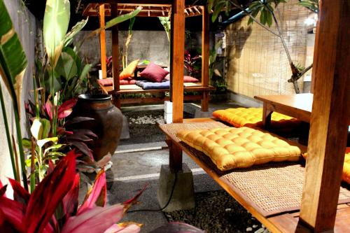 a patio with benches and plants in a garden at Yasa Backpackers house in Ubud
