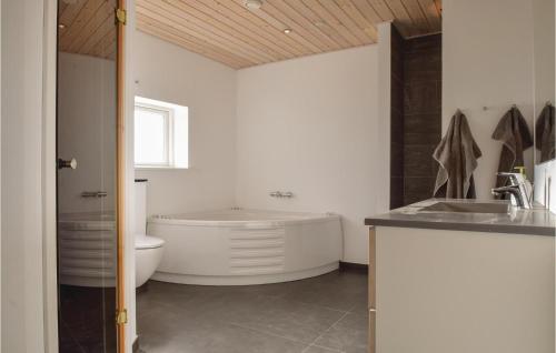 a bathroom with a tub and a toilet and a sink at Awesome Home In Rudkbing With Sauna in Spodsbjerg