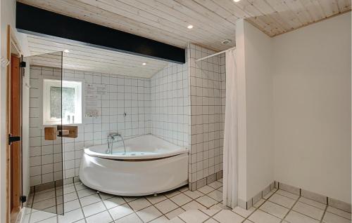 Vester SømarkenにあるNice Home In Nex With 4 Bedrooms, Sauna And Wifiのバスルーム(白いバスタブ、シャワー付)