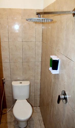 a bathroom with a toilet and a shower at Yasa Backpackers house in Ubud