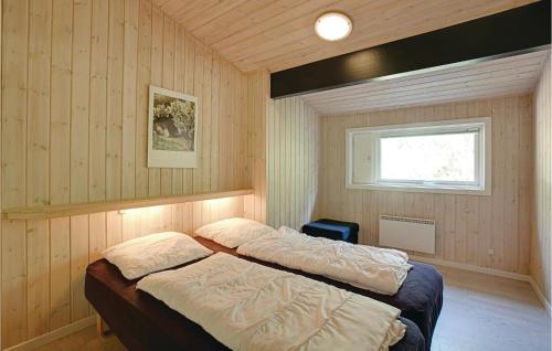 Vester SømarkenにあるNice Home In Nex With 4 Bedrooms, Sauna And Wifiのウッドウォールと窓が備わるドミトリールームのベッド2台分です。