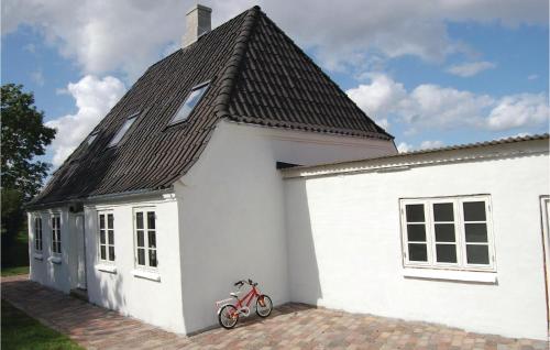 ein rotes Fahrrad, das vor einem weißen Haus parkt in der Unterkunft Tidligere Gammelmark 26 in Broager