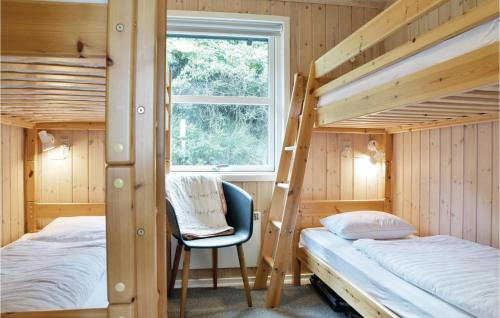 Fjand GårdeにあるAmazing Home In Ulfborg With 2 Bedroomsのベッドルーム1室(二段ベッド2台、椅子付)