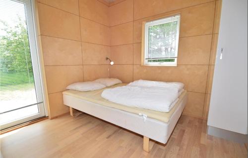 トランにあるStunning Home In Lgstr With 3 Bedrooms, Sauna And Wifiの窓2つが備わるドミトリールームの小さなベッド1台分です。