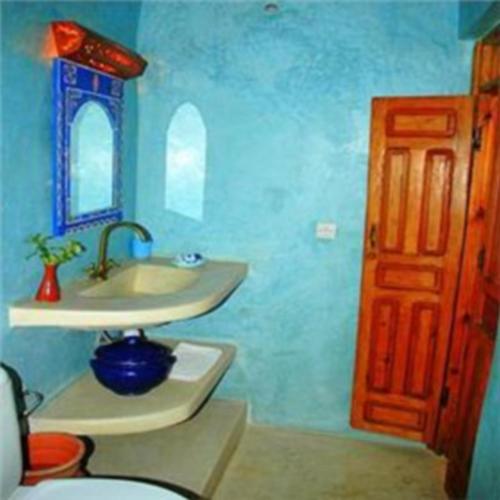 a bathroom with a sink and a toilet and a mirror at Riad Jade Mogador in Essaouira