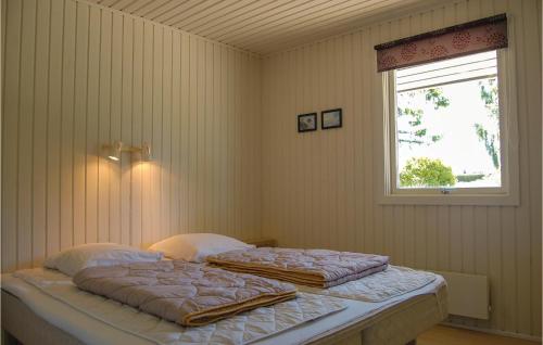 two beds in a bedroom with a window at Beautiful Home In Hejls With 3 Bedrooms And Wifi in Hejls