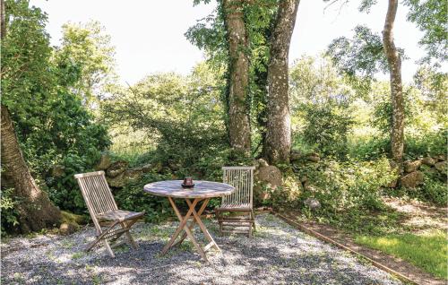 a table and two chairs sitting next to a tree at 0-Bedroom Apartment In Nexo in Neksø