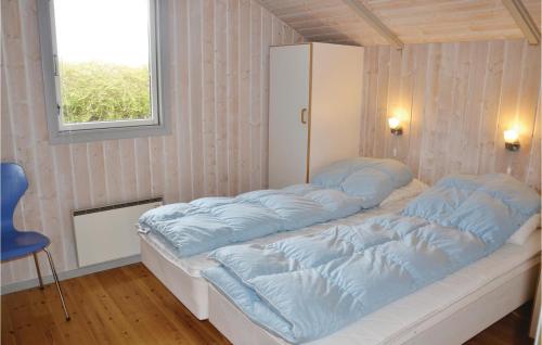 een bed met blauwe kussens in een kamer bij Nice Home In Kirke Hyllinge With Wifi in Kirke-Hyllinge