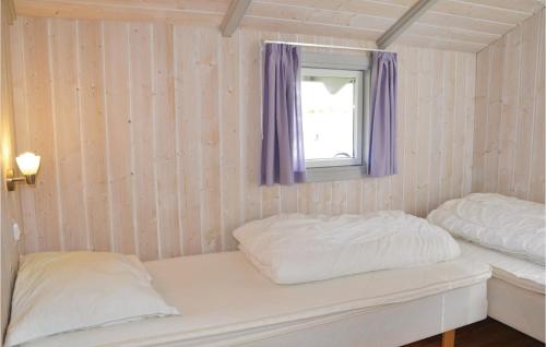 two beds in a room with a window and purple curtains at Holiday Home Åsen in Kirke-Hyllinge