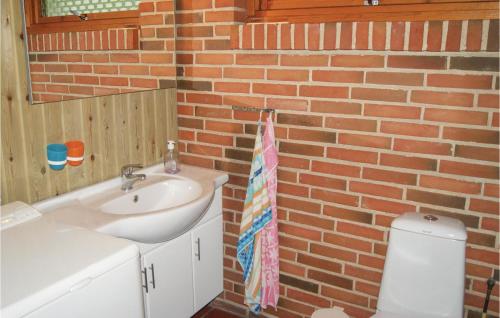 a bathroom with a sink and a brick wall at Beautiful Home In Spttrup With Wifi in Lihme