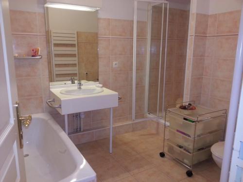 ein Badezimmer mit einem Waschbecken, einer Badewanne und einem WC in der Unterkunft Rochemarine in Théoule-sur-Mer