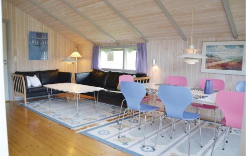 a living room with a couch and a table and chairs at Nice Home In Kirke Hyllinge With Wifi in Kirke-Hyllinge