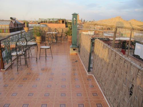 a patio with tables and chairs on a balcony at Sindi Sud in Marrakesh