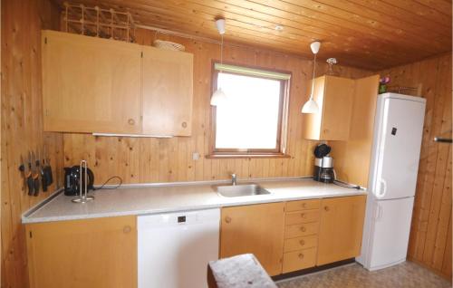 a kitchen with a white refrigerator and a sink at Awesome Home In Hvide Sande With Sauna in Havrvig