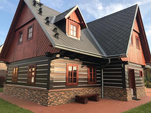 a house with a black roof at Wellness Chalupa Theo in Vrchlabí