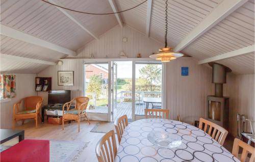 a dining room with a table and chairs and a room with a patio at Three-Bedroom Holiday Home In Brenderup Fyn in Vedelshave