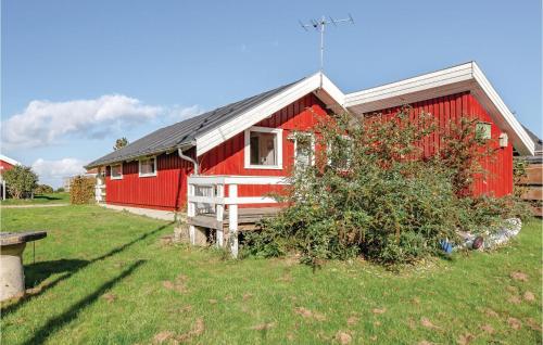 a red house with a yard with a bush in front of it at Three-Bedroom Holiday Home In Brenderup Fyn in Vedelshave