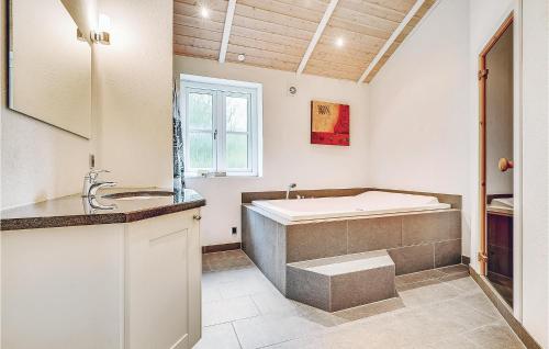 y baño con bañera y lavamanos. en Beautiful Home In Blvand With 5 Bedrooms, Sauna And Wifi en Blåvand