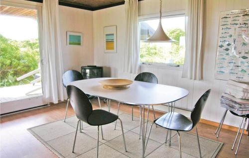 una sala da pranzo con tavolo e sedie bianchi di Holiday Home Svenstibakkevej Frøstrup Xii a Lild Strand