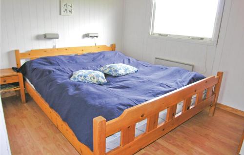 a bed with blue sheets and two pillows on it at Nice Home In Frstrup With Kitchen in Lild Strand